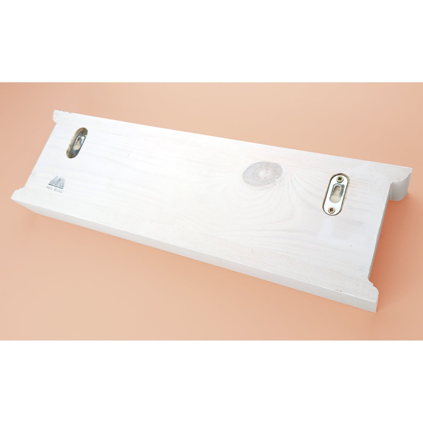 White rectangular object with metallic clips on a beige background