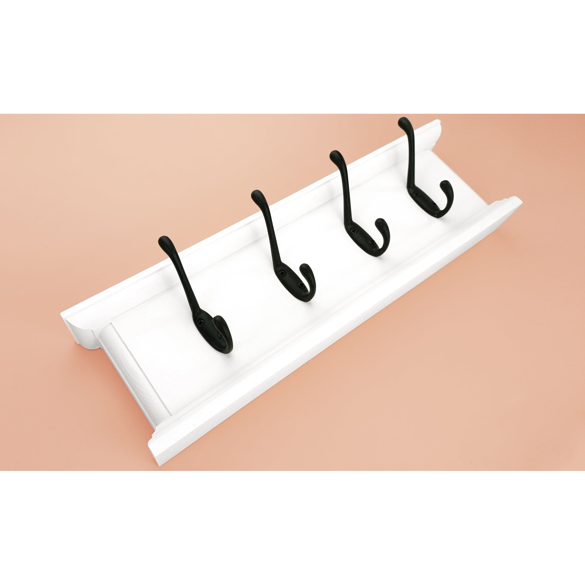 White wall hook with four black hooks on a beige background