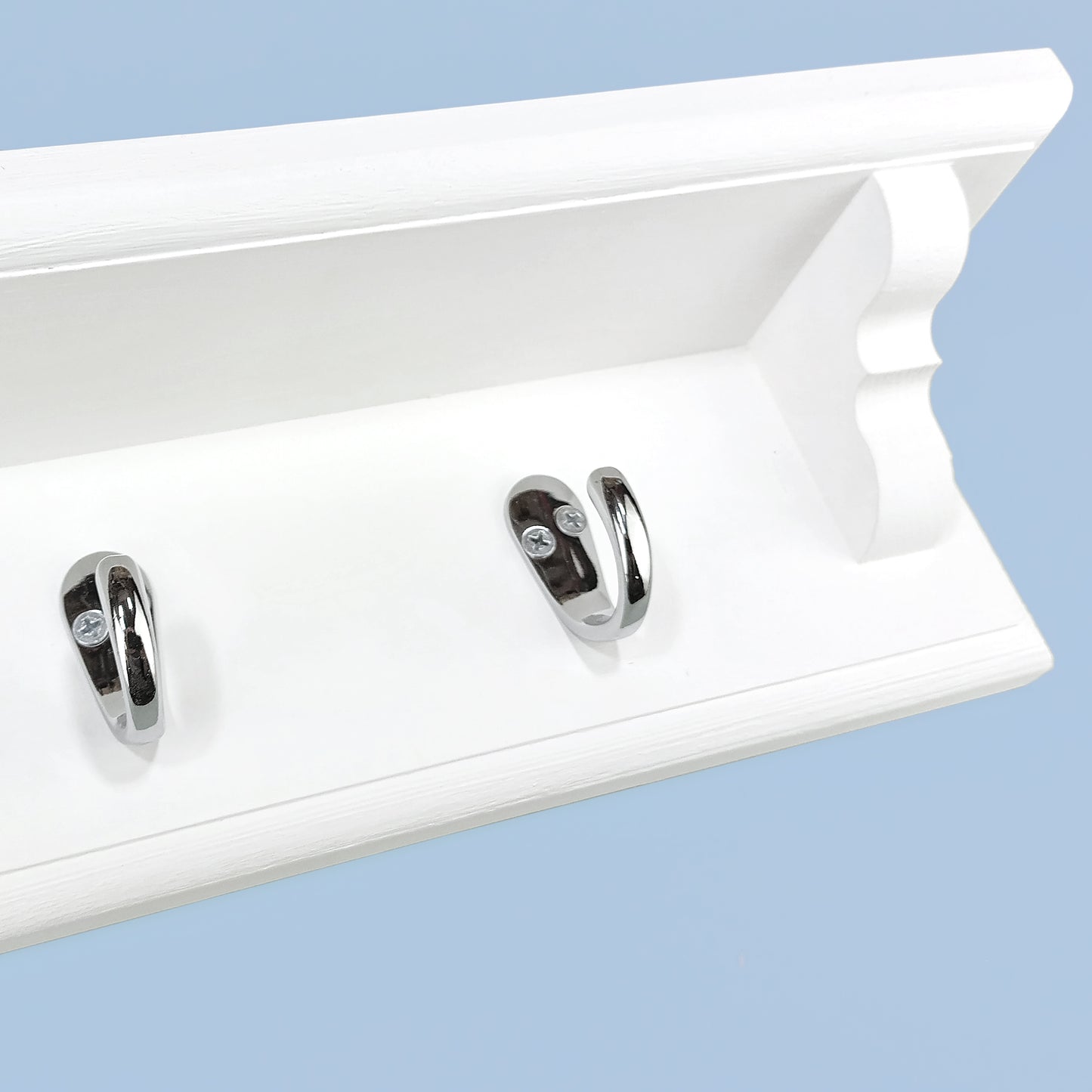 A coat rack with shelf and single metal hooks on a blue background