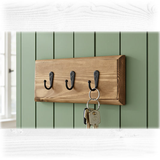 Wooden wall hook with three hooks on a green wooden panel background