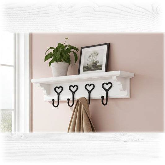 White wall shelf with heart-shaped hooks, plant, and picture frame against a pink wall.
